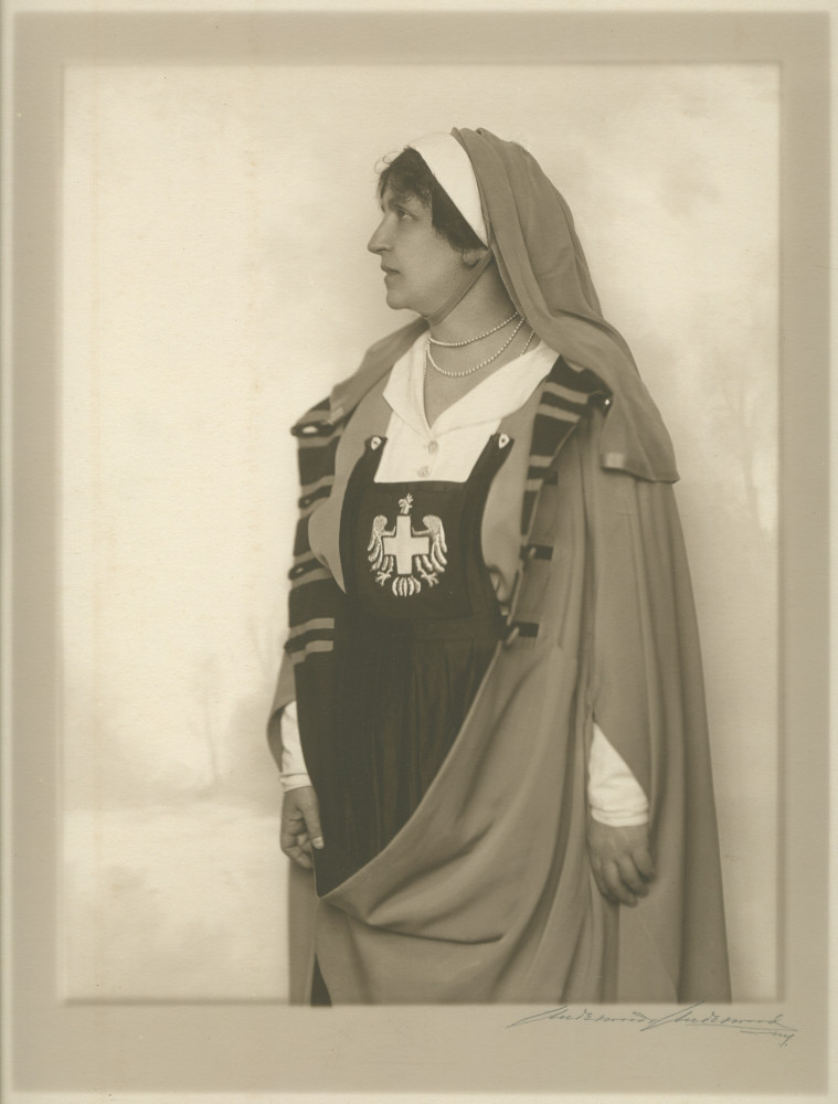 Photographie d'Hélène Paderewska dans son uniforme de la Croix Blanche polonaise, debout de profil avec une cape, réalisée sans doute à New York en 1918