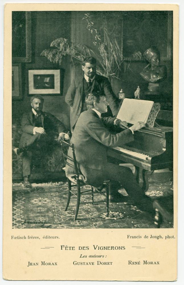 Carte postale représentant Gustave Doret (1866-1943) au piano et les frères Jean (1869-1939) et René Morax (1873-1963), auteurs de la Fête des Vignerons de 1905 – photographie de Francis de Jongh – éditée par Fœtisch Frères S.A. à Lausanne