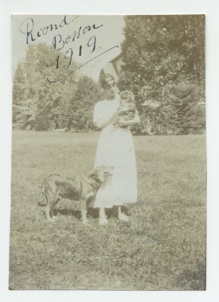 Photographie d'une jeune femme en 1919 dans le parc de Riond-Bosson, en compagnie de deux chiens