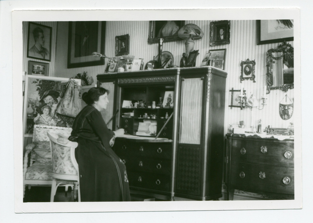 Photographie d'Hélène Paderewska écrivant à son secrétaire dans sa chambre à coucher de Riond-Bosson (nouveau décor)