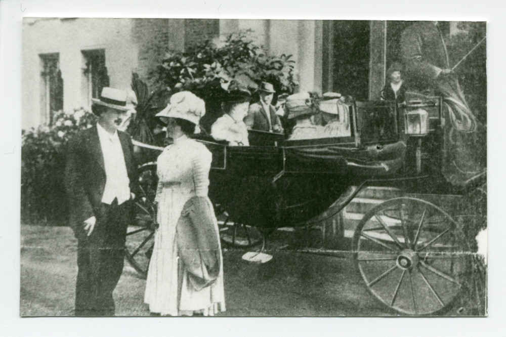 Photographie d'Hélène et Ignace Paderewski devant l'entrée principale de Riond-Bosson, avec derrière eux un landau conduisant trois dames