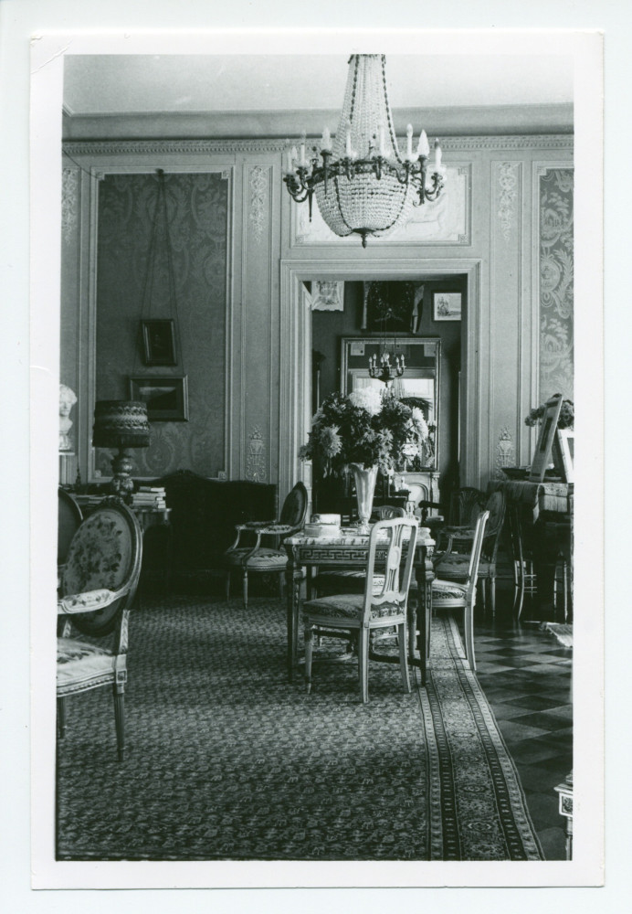 Photographie du salon de Riond-Bosson, prise depuis la salle à manger, avec au fond la porte menant au petit salon (dédié notamment au bridge)