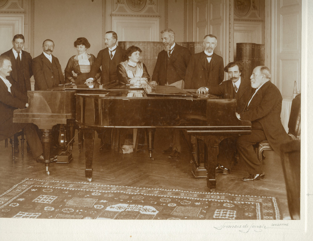 Photographie signée de Francis de Jongh représentant Paderewski et Camille Saint-Saëns face-à-face au piano dans les salons de l'Hôtel des Trois Couronnes à Vevey dans le cadre des Fêtes musicales données en mai 1913 en l'honneur de Camille Saint-Saëns