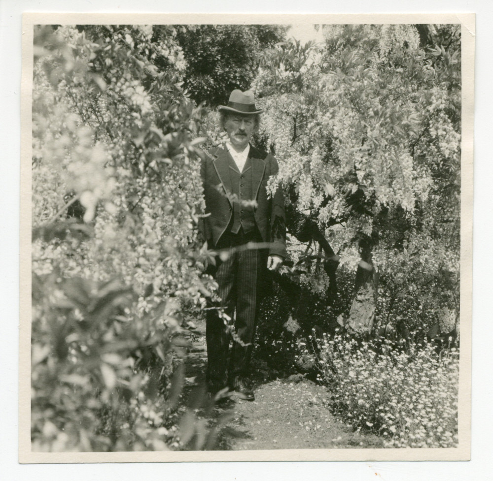 Photographie de Paderewski (avec son chapeau sur la tête) dans les jardins du château de Laeken, demeure de la famille royale de Belgique à Bruxelles, le 28 mai 1924