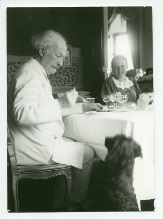 Photographie de Paderewski donnant à manger au chien Marius, à table à Riond-Bosson avec Anne Strakacz