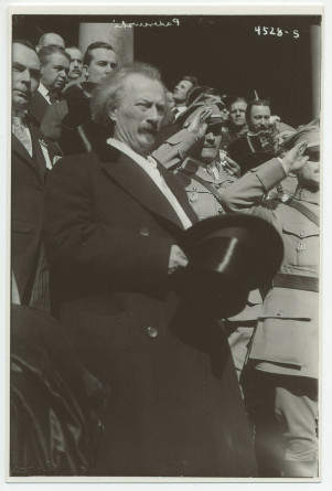 Photographie d'Ignace Paderewski se découvrant durant l'hymne national américain, sur les marches devant le City Hall de New York, en compagnie de militaires et officiels polonais, en mars 1918