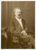 Photographie de Paderewski assis, avec une cigarette allumée dans la main gauche, prise vers 1910 par la London Stereoscopic & Photographic Company Limited