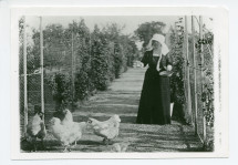 Photographie d'Hélène Paderewska nourrissant ses poules primées dans le jardin de Riond-Bosson