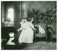 Photographie d'Hélène Paderewska assise dans le hall de Riond-Bosson avec une inconnue (Mme Obuchowicz?) et sa chienne Manon