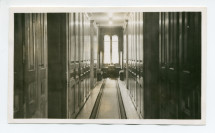 Photographie du corridor menant aux chambres des hôtes à Riond-Bosson, avec de chaque côté des armoires à linge