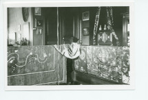 Photographie d'un coin de la galerie du 2e étage de Riond-Bosson, avec draperies et objets chinois, et au fond la porte menant à l'escalier de service